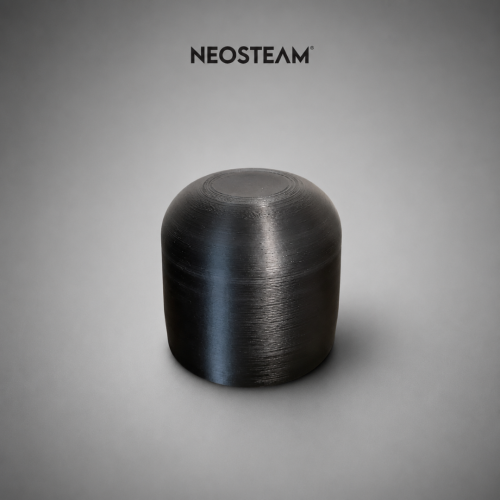 Black, dome-shaped 3D-printed part with concentric ring texture on a gray studio backdrop.