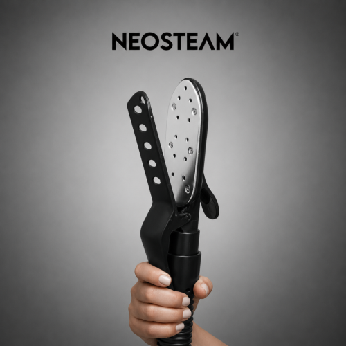 6 1 - NeoSteam Hand gripping a Neosteam handheld steam iron with a perforated soleplate against a gray studio backdrop.