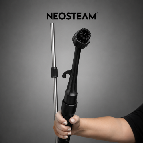 9 1 1 - NeoSteam Close-up of a hand holding a Neosteam hair styling wand with a round brush head and a metal rod against a gray background.