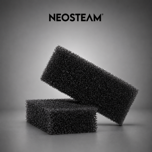 65 - NeoSteam Two black porous foam blocks stacked diagonally on a gray surface, with the NEOSTEAM logo above.