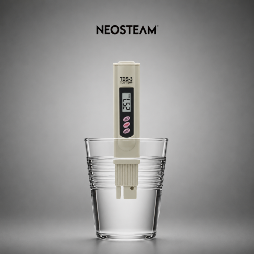 Neosteam TDS-3 water tester submerged in a glass of water, displaying a reading on its display.